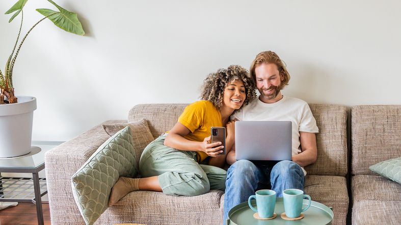 A couple looking at a laptop together at home